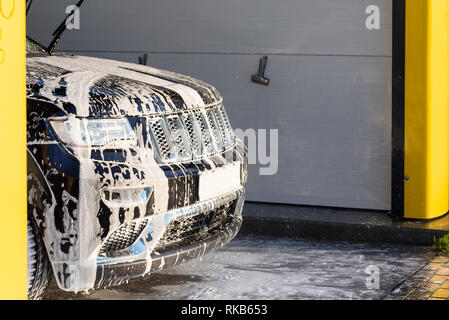 Schwarzes Auto mit weißen Seife auf den Körper in car wash. Stockfoto