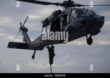 Marines mit 31 Marine Expeditionary Unit's Force Reconnaissance Platoon schnelle Seil von einem MH-60S Sea Hawk Hubschrauber vor einem simulierten besuchen, Board, Durchsuchung und Beschlagnahme Übung an Bord der Amphibisches Schiff USS Wasp (LL 1), Philippine Sea, Feb 6, 2019. Während des simulierten VBSS, Marines mit FRP probten die Beschlagnahme und Sicherstellung einer simulierten feindlichen Schiff mit Geschwindigkeit und entscheidende Maßnahmen Kontrolle der Brücke des Schiffes, den Maschinenraum und Viertel zu gewinnen. Die 31. MEU, das Marine Corps' nur kontinuierlich vorwärts - bereitgestellt MEU partnering mit dem Wasp amphibischen bereit, Gruppe, bietet eine Flexibl Stockfoto