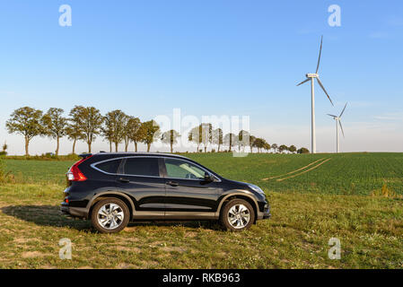 PUCK, Polen - 18. September 2018: Honda CR-V Auto in ein Feld auf einer Landstraße geparkt Neben einem Windpark Stockfoto