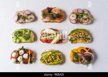 Auswahl an Sandwiches und Tapas mit Brot, Käse, Gemüse und leckeren Saucen. Gesunde Lebensmittel für das Mittagessen oder Frühstück. Weißer Hintergrund. Wohnung La Stockfoto