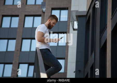 Junger bärtiger Mann verschränkte die Arme über seiner Brust vor dem Bürogebäude Stockfoto