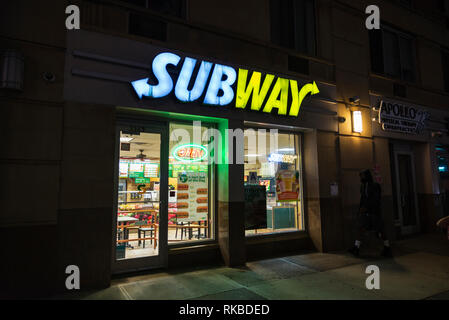 New York City, USA - 27. Juli 2018: Subway Restaurant in der Nacht mit einem Mann zu Fuß in Harlem, Manhattan, New York City, USA Stockfoto