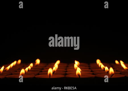 Eine lizenzfreie Bild der Zeilen von Kerzen, die man für immer, mit einem schwarzen Oberteil zu gehen scheinen. Stockfoto