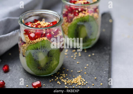 Joghurt Parfait mit Gepuffte Quinoa, Kiwi und Granatapfel Samen, gesunden Dessert Stockfoto