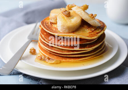 Stapel von hausgemachte Pfannkuchen mit Banane, Nüssen und Honig, Glutenfrei Haferkleie Pfannkuchen, gesundes Frühstück Stockfoto