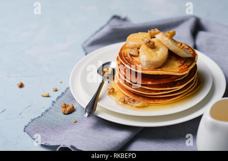 Stapel von hausgemachte Pfannkuchen mit Banane, Nüssen und Honig, Glutenfrei Haferkleie Pfannkuchen, gesundes Frühstück Stockfoto