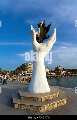 KUSADASI, Türkei - 23. MAI 2015: die Hand des Friedens Skulptur mit Tauben auf der Uferpromenade in Kusadasi, Türkei. Stockfoto