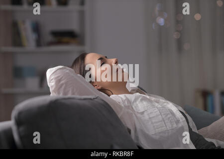 Seitenansicht Porträt einer Frau ruhen bequem auf einer Couch in der Nacht zu Hause Stockfoto