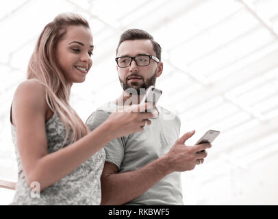 Junges Paar an die Bildschirme von ihren Smartphones. Foto mit Kopie Raum Stockfoto