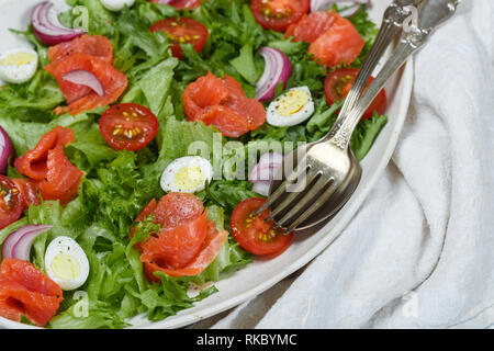 Lecker Salat Salat mit gesalzenen oder geräucherten Lachs (Forelle) Cherry Tomaten, Wachteleier, roten Zwiebeln und Gewürzen mit Olivenöl und Senf Dressing. S Stockfoto