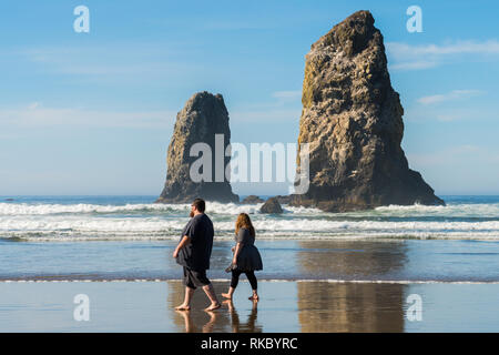 Ein paar Spaziergänge genießen die Sonne bei Cannon Beach, Oregon, USA. Stockfoto
