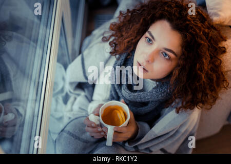 Curly Frau mit Schal Niesen und Husten leiden. Stockfoto