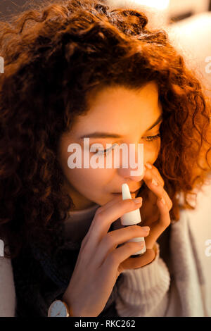 Der junge rothaarige Frau mit Nasenspray zu Hause Stockfoto
