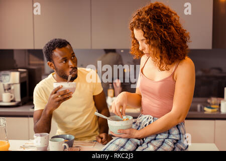 Curly Freundin sitzen am Tisch beim Frühstück mit ihrem Mann Stockfoto