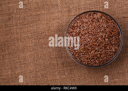 Rohstoff Flachs Samen in Glasschale auf darck Hintergrund Draufsicht, Platz für Text. Vegan protein Quelle. Superfoods und gesunde Lebensmittel sauber essen. Stockfoto