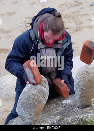 Von Cornwall Stein balancing Künstlers Carlos macht eine überraschung Besuch von Newquay Towan Beach. 10. Februar 2019, Robert Taylor/Alamy leben Nachrichten. Newquay, Stockfoto