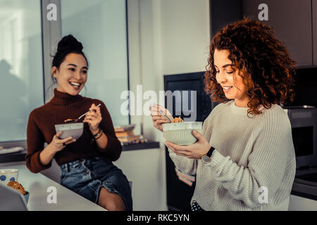 Curly rothaarige Frau, die ihr Frühstück genießen mit Freund Stockfoto