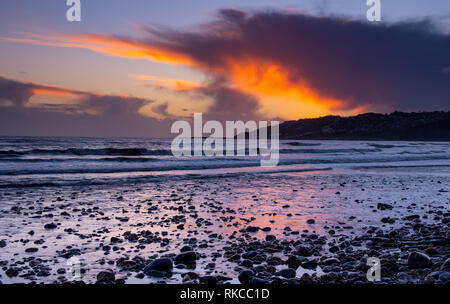 Charmouth, Dorset, Großbritannien. 10. Februar 2019. UK Wetter: Die moody Abend Himmel bei Charmouth blühen vibrant orange Farbe bei Sonnenuntergang am Sonntag abend eingestellt. Nach einem Wochenende der starken Winde und Regen durch Sturm Erik eine Zeit der Ruhe und Mehr nieder Wetter für den Südwesten diese Woche prognostiziert ist. Credit: PQ/Alamy leben Nachrichten Stockfoto