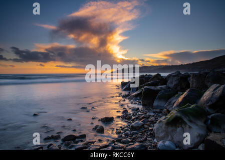 Charmouth, Dorset, Großbritannien. 10. Februar 2019. UK Wetter: Die moody Abend Himmel bei Charmouth blühen vibrant orange Farbe bei Sonnenuntergang am Sonntag abend eingestellt. Nach einem Wochenende der starken Winde und Regen durch Sturm Erik eine Zeit der Ruhe und Mehr nieder Wetter für den Südwesten diese Woche prognostiziert ist. Credit: PQ/Alamy leben Nachrichten Stockfoto