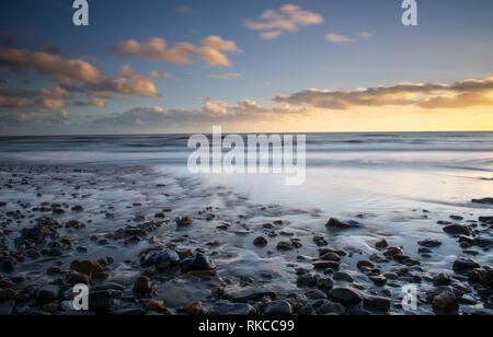 Charmouth, Dorset, Großbritannien. 10. Februar 2019. UK Wetter: Die moody Abend Himmel bei Charmouth blühen vibrant orange Farbe bei Sonnenuntergang am Sonntag abend eingestellt. Nach einem Wochenende der starken Winde und Regen durch Sturm Erik eine Zeit der Ruhe und Mehr nieder Wetter für den Südwesten diese Woche prognostiziert ist. Credit: PQ/Alamy leben Nachrichten Stockfoto