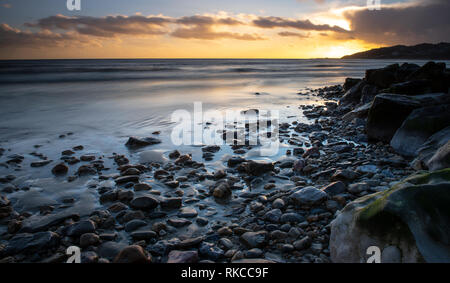 Charmouth, Dorset, Großbritannien. 10. Februar 2019. UK Wetter: Die moody Abend Himmel bei Charmouth blühen vibrant orange Farbe bei Sonnenuntergang am Sonntag abend eingestellt. Nach einem Wochenende der starken Winde und Regen durch Sturm Erik eine Zeit der Ruhe und Mehr nieder Wetter für den Südwesten diese Woche prognostiziert ist. Credit: PQ/Alamy leben Nachrichten Stockfoto