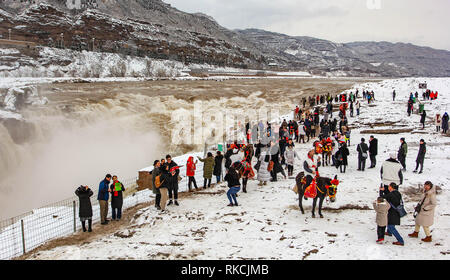 Peking, der chinesischen Provinz Shanxi. 10 Feb, 2019. Touristen die Hukou Wasserfall des Gelben Flusses im Schnee in Jixian County, im Norden der chinesischen Provinz Shanxi, 10.02.2019. Schneefall hat viele Regionen im südlichen Teil der Provinz, der Hit seit Samstag. Quelle: Rao Beicheng/Xinhua/Alamy leben Nachrichten Stockfoto