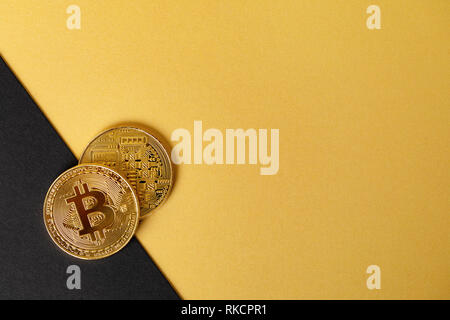 Gold bitcoin cryptocurrency Münzen auf Split gold gelb und schwarz hintergrund Stockfoto