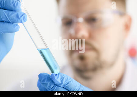 Eine männliche Chemiker hält Reagenzglas aus Glas Stockfoto