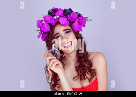 Frau mit Blumen Krone holding Parfüm Flasche lachen Stockfoto