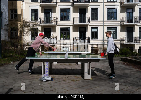 Zwei Freunde spielen eine Partie Tischtennis auf eine Tischtennisplatte in einem Park in Oslo, Norwegen Stockfoto