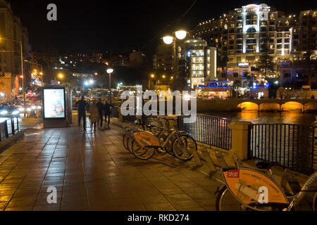 Abendlicher Blick von der Promenade rund um die Bucht von St.Julian's Malta mit hellen Lichtern Stockfoto