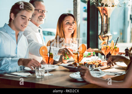 Blonde schöne Frau zu Mittag mit ihren besten Freunden an einem trendigen Restaurant Stockfoto