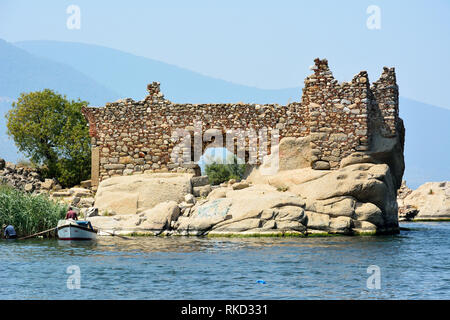 Kapikiri, Mugla, Türkei - August 1, 2016. Alte Befestigungsanlagen auf einer Insel im Bafa See aus Dorf Kapikiri in Mugla, Türkei, mit Menschen. Stockfoto