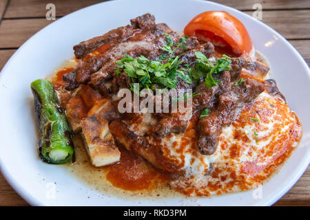 Türkische manisa Kebap serviert auf Fladenbrot mit Soße und Joghurt. Stockfoto