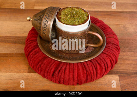 Türkischer Kaffee mit Haselnuss in eine Schale von einer Kupfer Deckel versehen und auf einem weichen Getränkehalter ähnelt einem Pascha hat serviert. Stockfoto