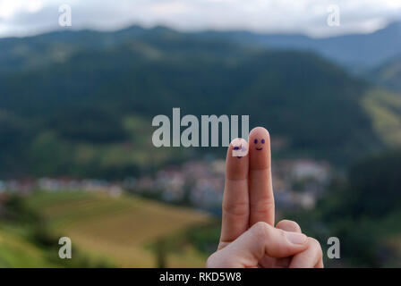 Paar Gesicht am Finger auf Landschaft Hintergrund gemalt, glückliches Paar Konzept Stockfoto