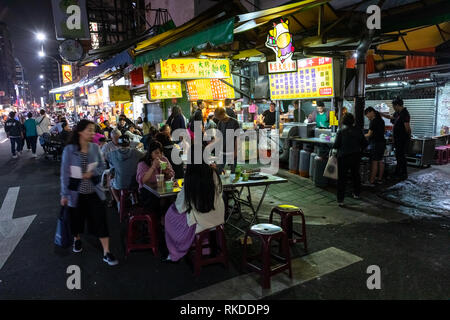 Taipei Bewohner kaufen Sie Lebensmittel aus Essen Anbieter an einem lokalen Essen Nachtmarkt in Daan Bezirk in Taipei, Taiwan Stall, dort zu essen oder zum Mitnehmen. Stockfoto