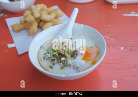 Reis Suppe oder Congee Schweinehack und Innereien mit Ei an Witz kun pa Restaurants in Amphoe Pak Chong, Korat, Thailand Stockfoto