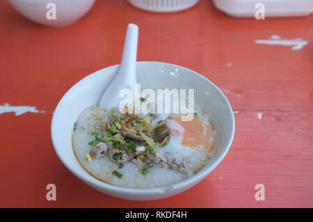 Reis Suppe oder Congee Schweinehack und Innereien mit Ei an Witz kun pa Restaurants in Amphoe Pak Chong, Korat, Thailand Stockfoto