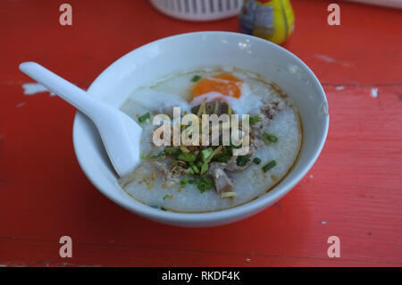 Reis Suppe oder Congee Schweinehack und Innereien mit Ei an Witz kun pa Restaurants in Amphoe Pak Chong, Korat, Thailand Stockfoto