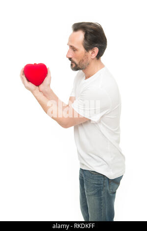 Valentines Tag feiern. Liebe und romantische Gefühle Konzept. Herz-Attribut von Valentine. Herz Geschenk präsentieren. Gruß aus ehrlichem Herzen. Man bärtige Hipster halten Herz. Romantischer Kerl verlieben. Stockfoto