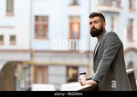 Entspannen und erholen Sie sich. Man bärtige hipster Kaffee trinken Pappbecher. Noch ein Schluck Kaffee. Stadt Lebensstil. Geschäftsmann gepflegt aussehen genießen Sie Kaffee Pause aus Business Center im städtischen Hintergrund. Stockfoto