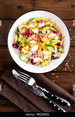Gesunde vegetarische Gemüse Salat mit frischen, rohen Rettich, Karotten, Sellerie, Kopfsalat, Sesam und Leinsamen. Vegane Ernährung Essen Stockfoto