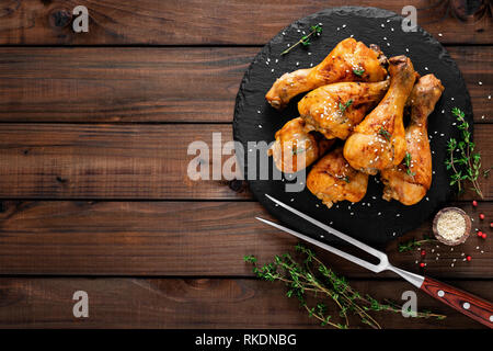 Gegrillte Hähnchenschenkel auf Holz- Hintergrund. Ansicht von oben Stockfoto