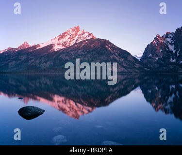 USA, Wyoming, Grand Teton National Park, Sonnenaufgang am Grand Teton reflektiert in den Jenny See; Teton Bergkette. Stockfoto