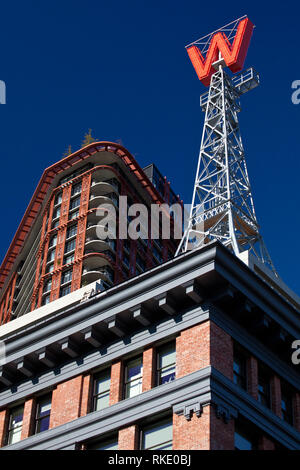Die woodwards W Zeichen, montiert auf einem mini Replik des Eiffelturms, in der Nähe von einem sanierten Bereich der Downtown Eastside von Vancouver, British Columbia. Stockfoto