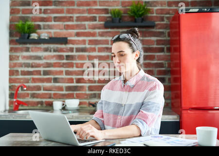 Junge Frau von zu Hause aus arbeiten Stockfoto