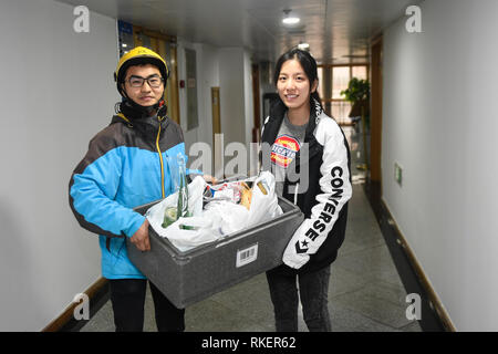 Peking, der chinesischen Provinz Zhejiang. 3 Feb, 2019. Zhou Xiaoyu (R) empfängt frische Zutaten für Familientreffen Abendessen auf dem chinesischen Neujahr von einem deliveryman in Hangzhou, China Zhejiang Provinz, Feb 3, 2019. Credit: Huang Zongzhi/Xinhua/Alamy leben Nachrichten Stockfoto