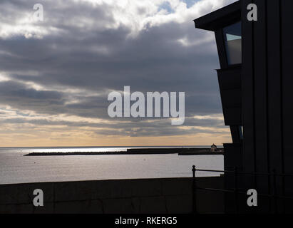 Lyme Regis, Dorset, Großbritannien. 11. Februar 2019. UK Wetter: Ein heller Tag mit viel Sonne an der Küste von Lyme Regis. Eine Fernsicht von Lyme Regis Museum mit der ikonischen Cobb Silhouette gegen das glitzernde Meer in der Ferne. Credit: Celia McMahon/Alamy leben Nachrichten Stockfoto