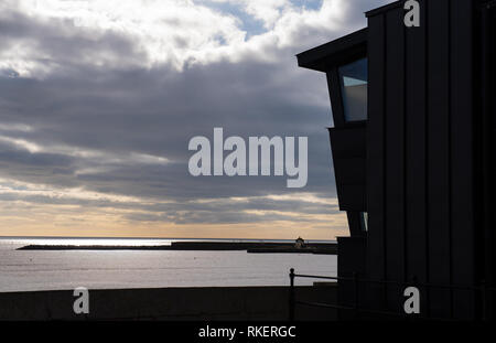 Lyme Regis, Dorset, Großbritannien. 11. Februar 2019. UK Wetter: Ein heller Tag mit viel Sonne an der Küste von Lyme Regis. Eine Fernsicht von Lyme Regis Museum mit der ikonischen Cobb Silhouette gegen das glitzernde Meer in der Ferne. Credit: Celia McMahon/Alamy leben Nachrichten Stockfoto